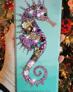 a person holding up a phone case with a sea horse on it