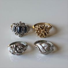 "Vintage 1970s Avon costume rings. The rings vary in size.  Some of the rings have tension bands that allows the ring to fit a slightly smaller or larger finger - approximately 1/2 size up or down. All of the rings are in good to fair condition overall, with wear to the bands. Please read the detailed description below. 1972  Avon \"Midnight Splendor\" size 7 simulated hematite ring in silver tone metal. It is accented with 2 small cz stones.  The ring is not adjustable. It is in good condition Starburst Ring, Avon Rings, Hematite Ring, Sun Flare, Love Knot Ring, Native American Necklace, Avon Vintage, Costume Rings, Floral Ring