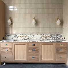 a bathroom with marble counter tops and wooden cabinets