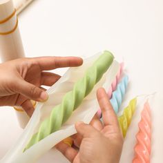 a person is holding four different colored toothbrushes in their hands and pointing at them