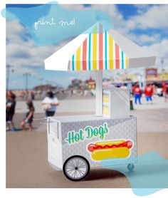 a hot dog cart on the beach with people in the background