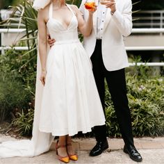 a man and woman standing next to each other holding wine glasses in their hands while posing for the camera