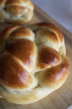 two hot cross buns sitting on top of a cutting board