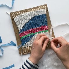 someone is working on an art project with yarn and paper streamers in the background