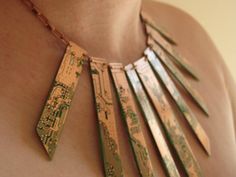 a close up of a woman wearing a necklace made out of wooden sticks with writing on it