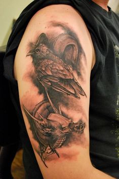 a man with a tattoo on his arm has two birds perched on top of each other