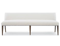 an upholstered white bench with wood legs and back rests against a white background