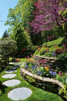 a garden with stepping stones in the grass and flowers growing on it's sides