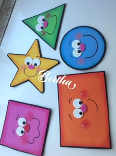 four different colored magnets with faces and eyes on them, one has a star in the middle