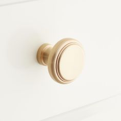 a close up of a knob on a white cabinet