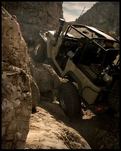 an off - road vehicle driving through the rocky terrain