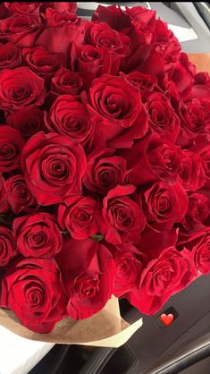 a bouquet of red roses sitting on top of a table