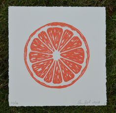 an orange cut in half sitting on top of grass