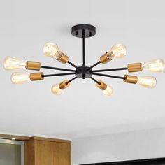 a chandelier with six lights hanging from the ceiling in a living room or kitchen