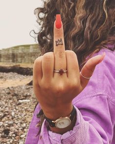 a woman with her finger in the shape of an m on her index pointing to the camera