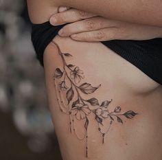 a close up of a woman's stomach with tattoos on her belly and flowers