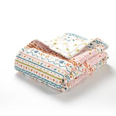 three blankets stacked on top of each other in different colors and patterns, with one folded up