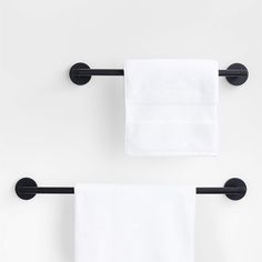 two black towel racks with white towels hanging on them