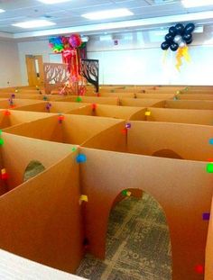 a room filled with lots of cardboard boxes and colorful confetti on the walls