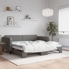 a living room with a couch, table and lamp on the wall next to it