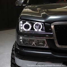 the front end of a black truck with chrome rims and lights on it's headlight