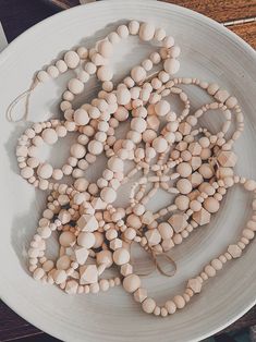 a white bowl filled with wooden beads on top of a table