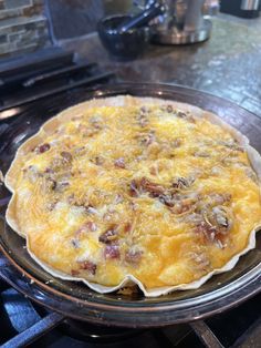 an omelet sitting on top of a metal pan in front of a stove