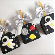 some little magnets that are decorated with space related items and bows on top of them