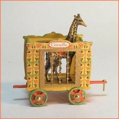 a toy giraffe is in a small cart