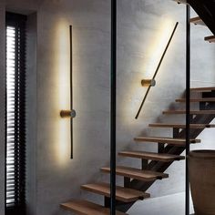 a stair case with two lights on the side and some wooden steps in front of it