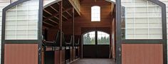 the inside of a horse stable with doors open