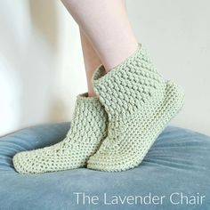 there is a woman's legs with crochet socks on top of a chair