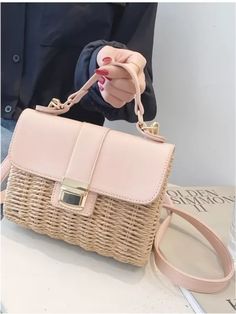 a woman holding a pink purse on top of a table