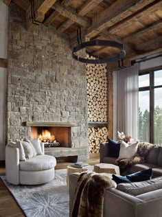 a living room filled with furniture and a fire place next to a large stone wall