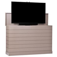 a flat screen tv sitting on top of a wooden box next to a white wall