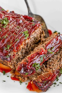 sliced meatloaf with ketchup and garnish on a white plate