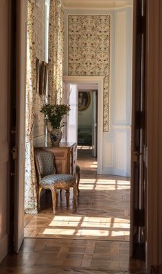 an open door leading to a hallway with floral wallpaper on the walls and floor