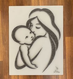 a drawing of a woman holding a baby on top of a white paper with black dots