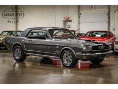 an old mustang car is parked in a garage