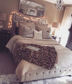 a bedroom with a bed, chandelier and pictures on the wall above it