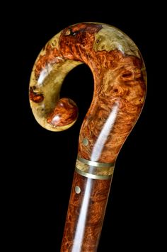 a close up of a wooden pipe with metal fittings and wood grain on it