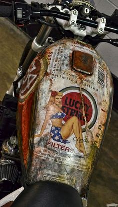 the back end of a motorcycle with an old advertisement on it's side panel