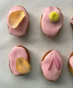 four cupcakes with pink icing and a flower on top are arranged in a circle