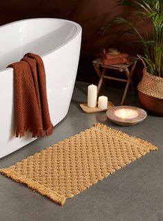 a bathroom with a bathtub and candles on the floor