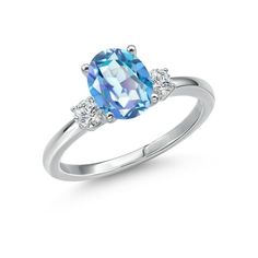 a ring with an oval blue topazte and three diamonds on the sides, set in white gold