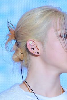 a woman with blonde hair and ear piercings