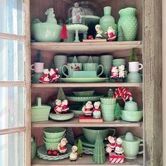 a shelf filled with green dishes and christmas decorations