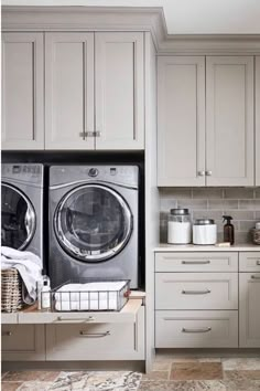 a washer and dryer sitting in a kitchen next to each other on top of cabinets