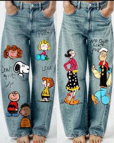 two pairs of jeans with cartoon characters painted on the legs and ankles, both showing their feet