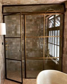 a bath tub sitting under a window next to a shower head mounted faucet